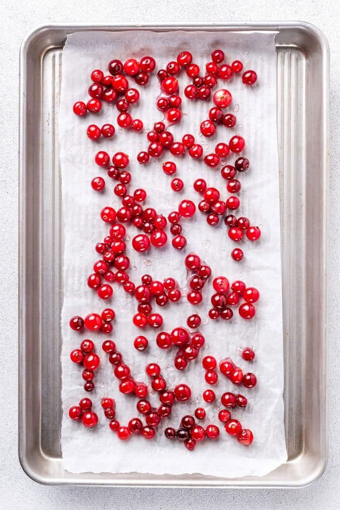 Glazed cranberries drying on a baking sheet