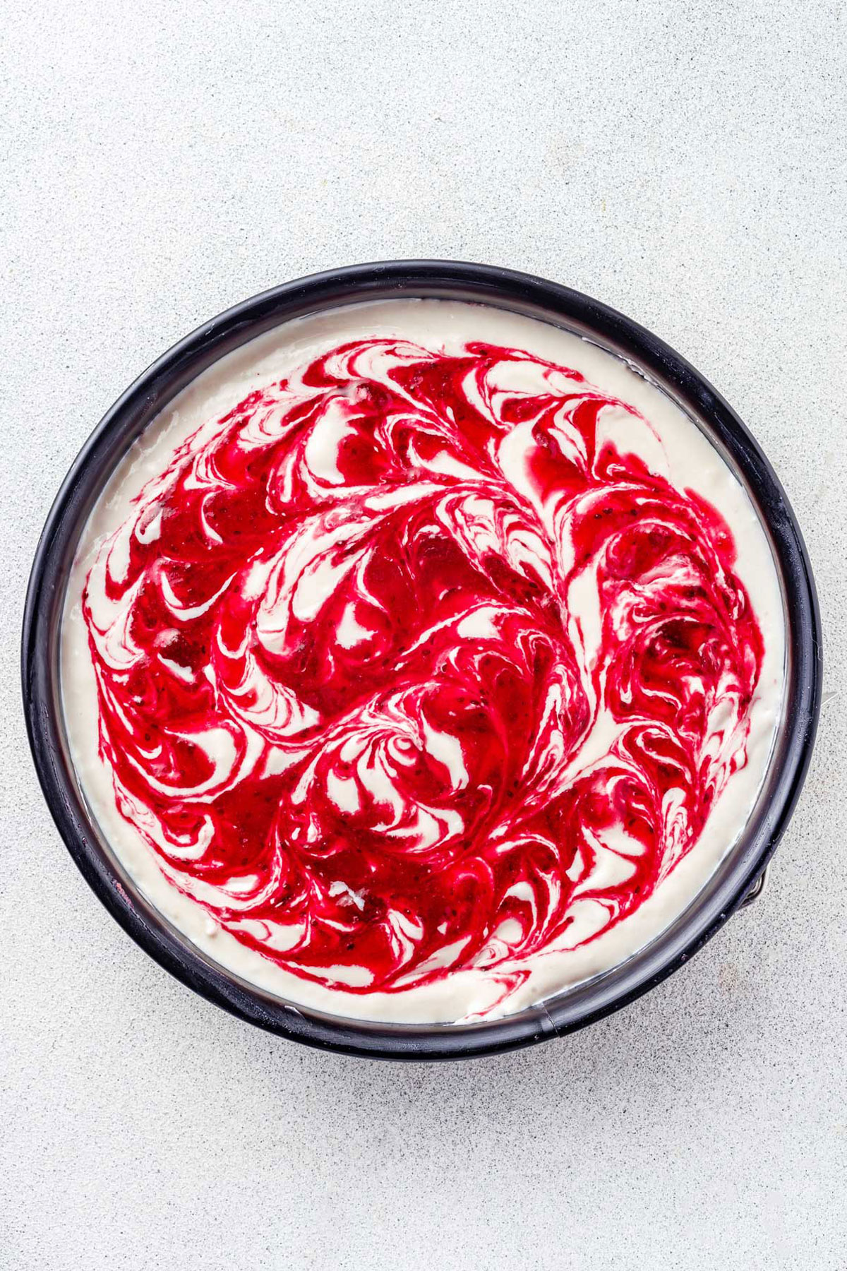 Top of no-bake cheesecake swirled with cranberry sauce