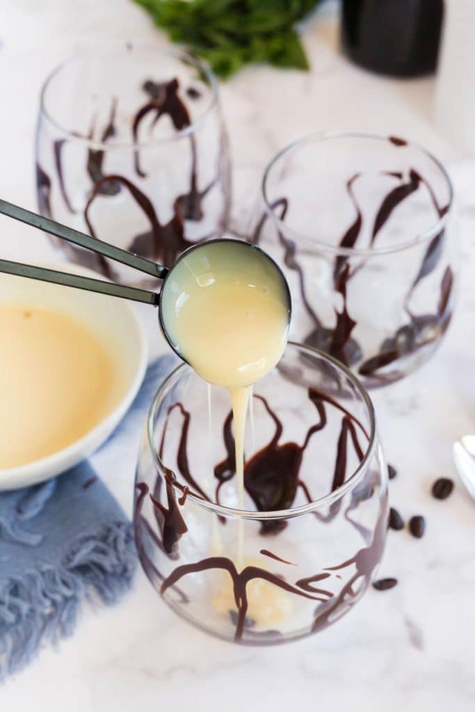 pouring sweetened condensed milk to a Chocolate drizzled glass