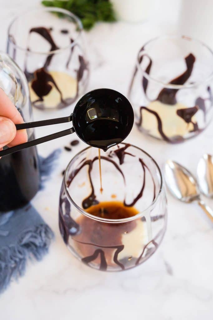 pouring kahlua to a Chocolate drizzled glass with condensed milk