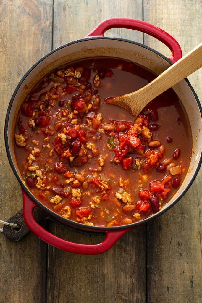 simmering ground turkey chili in a red dutch oven