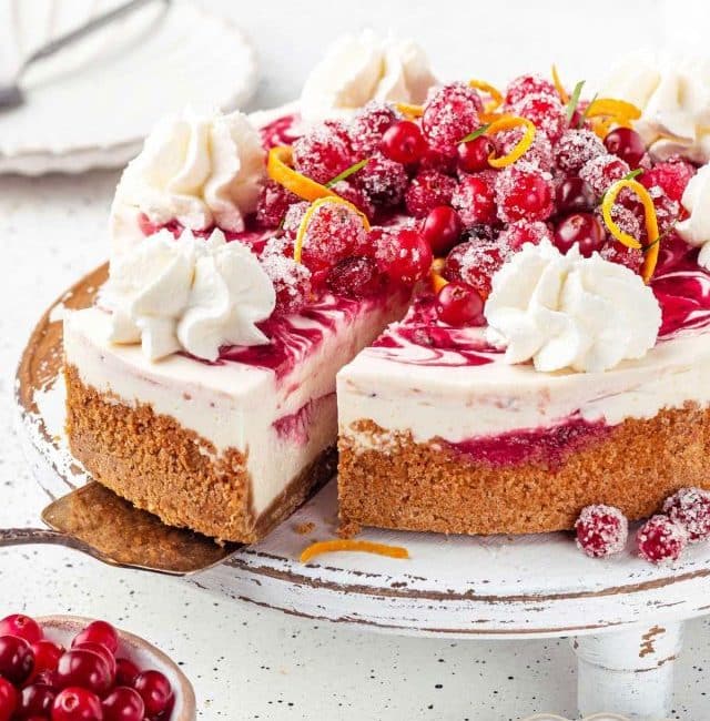 Serving a slice of creamy cranberry cheesecake from a cake platter