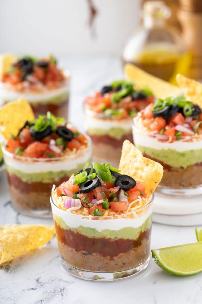 Clear plastic cups filled with 7 layer dip.