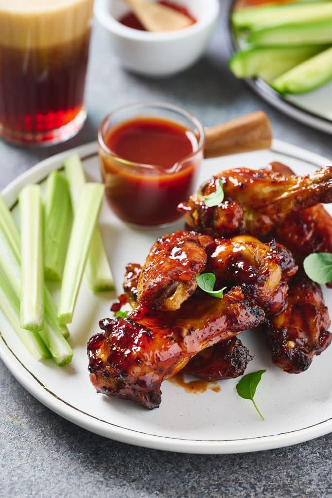 crispy chicken wings with bbq sauce on a white plate 