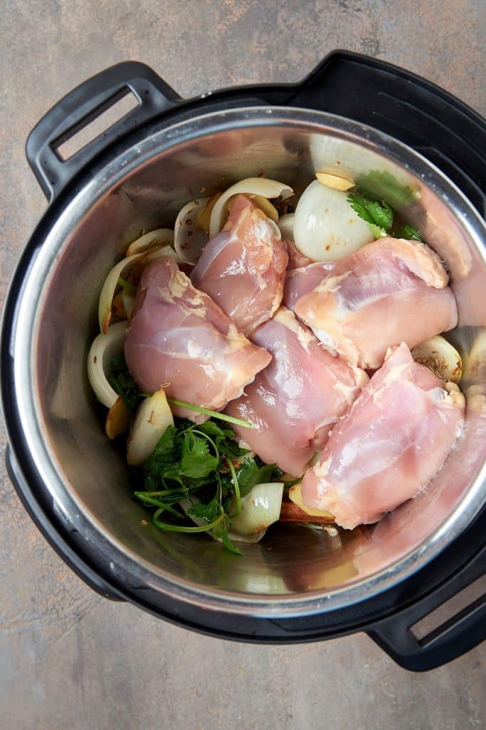 chicken thighs, onions, garlic and cilantro cooking in the instant pot