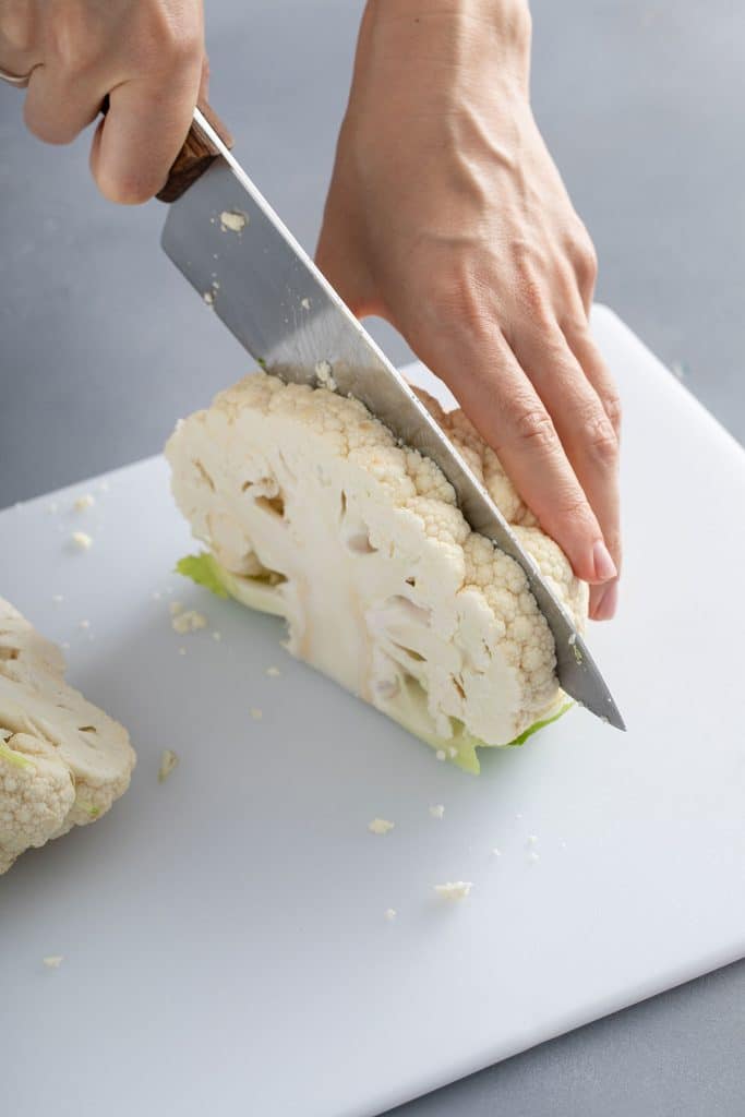 Cutting thick slices of cauliflower on a cutting board
