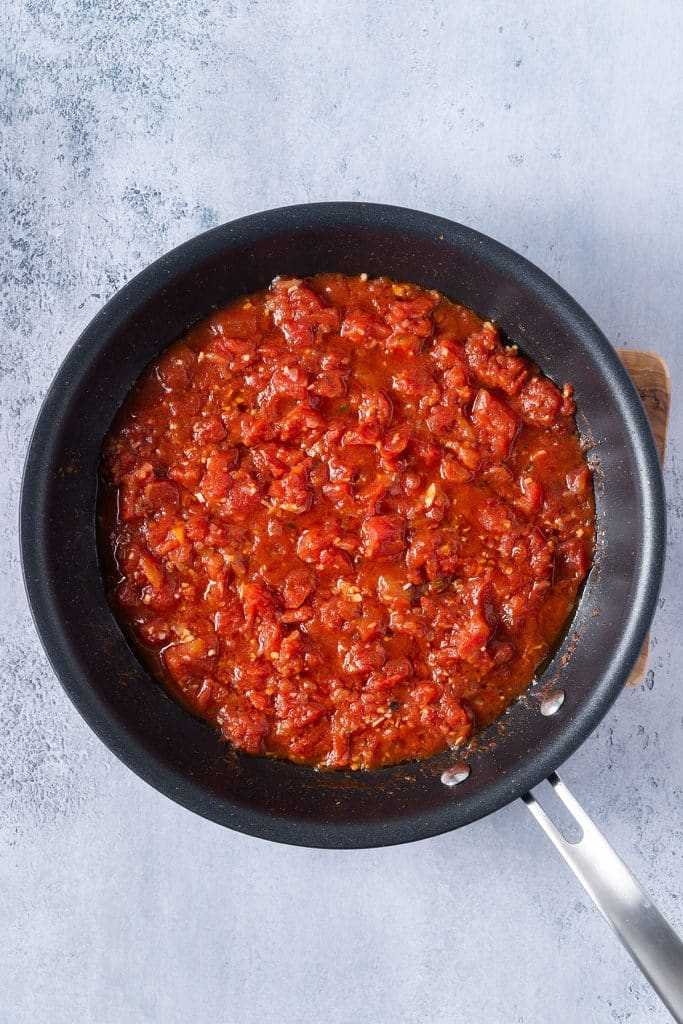 simmering the tomato sauce in a pan