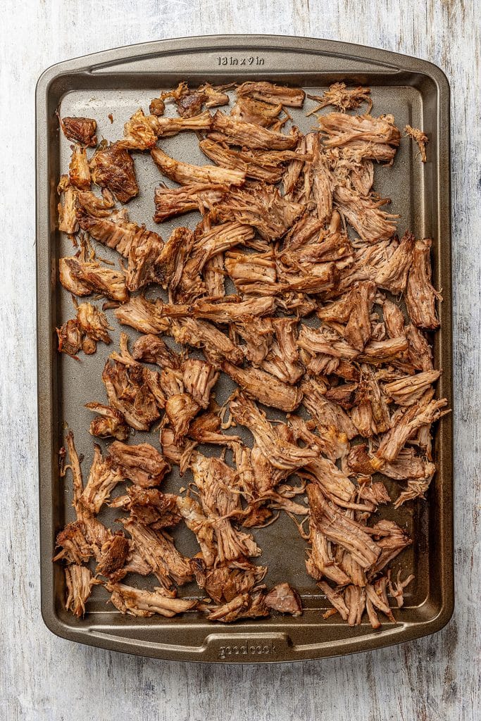 cooked golden brown carnitas on a baking sheet