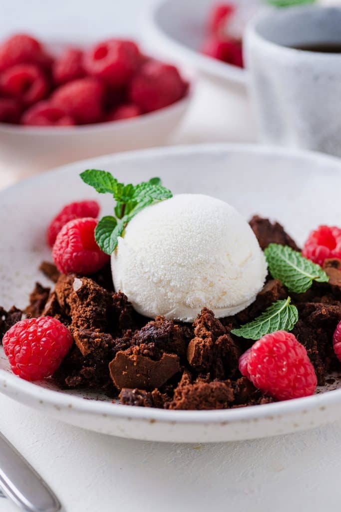 Brownie pudding topped with vanilla ice cream and berries.