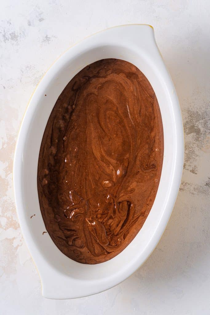 Chocolate batter in an oval baking dish.