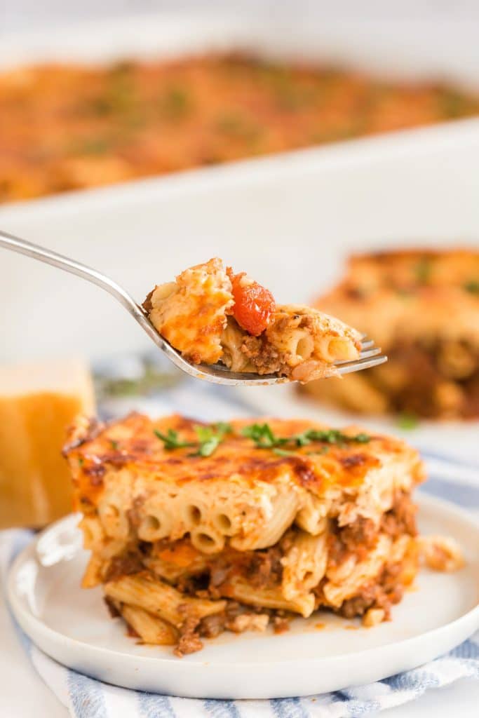 lifting a bite of pastitsio with a fork