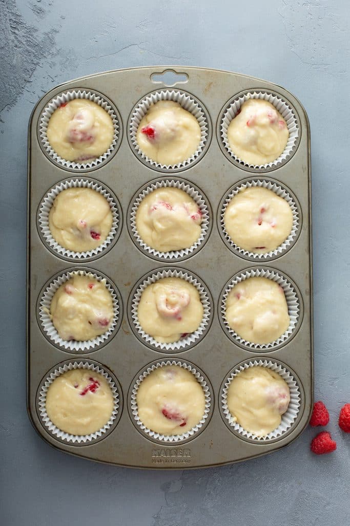raspberry muffin batter on a muffin pan