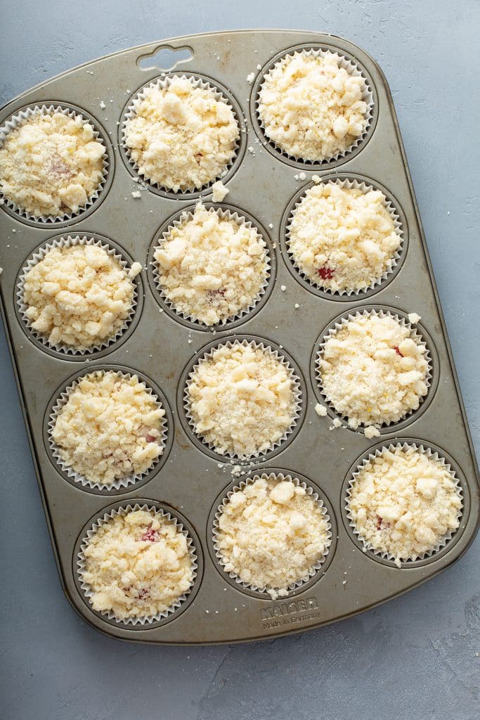 lemon streusel over the raspberry muffin batter on a muffin pan