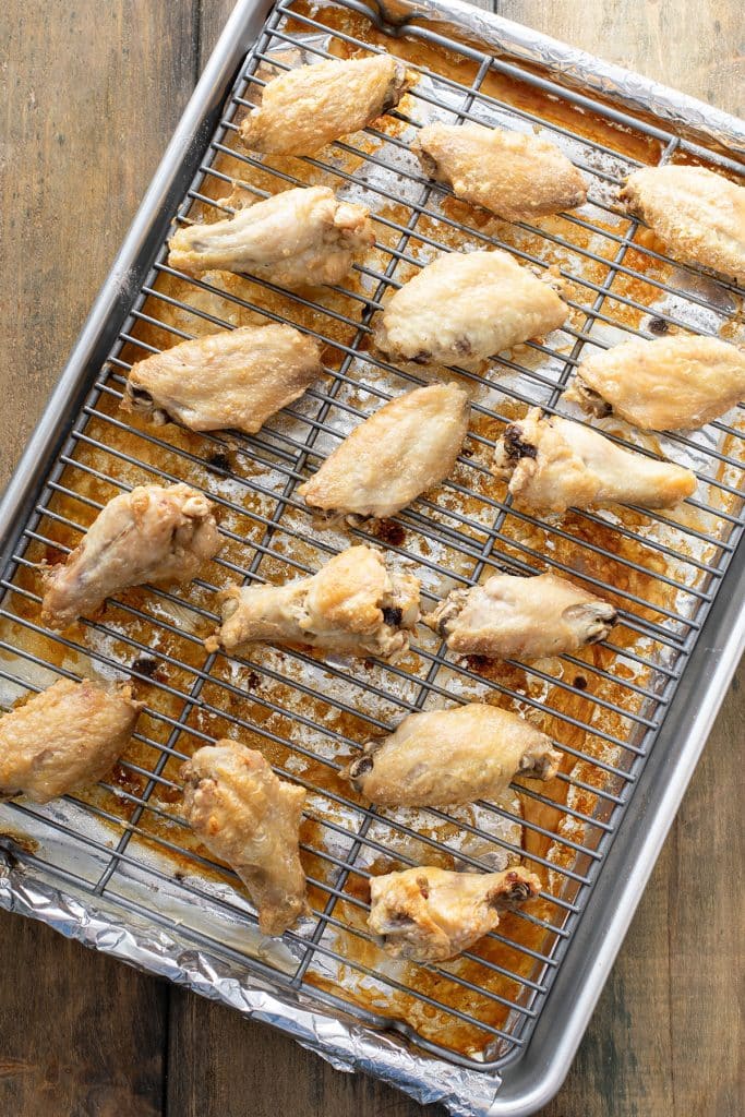 baked wings lined on a baking sheet