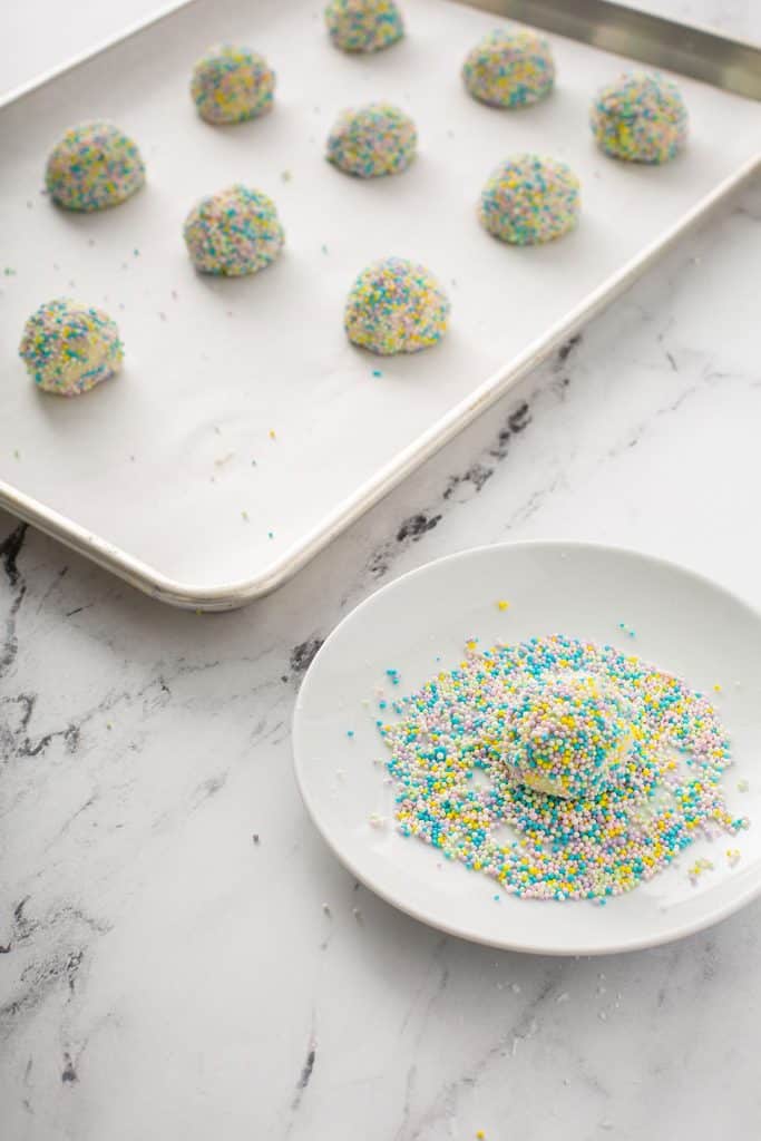 rolling the funfetti ball dough in sprinkles