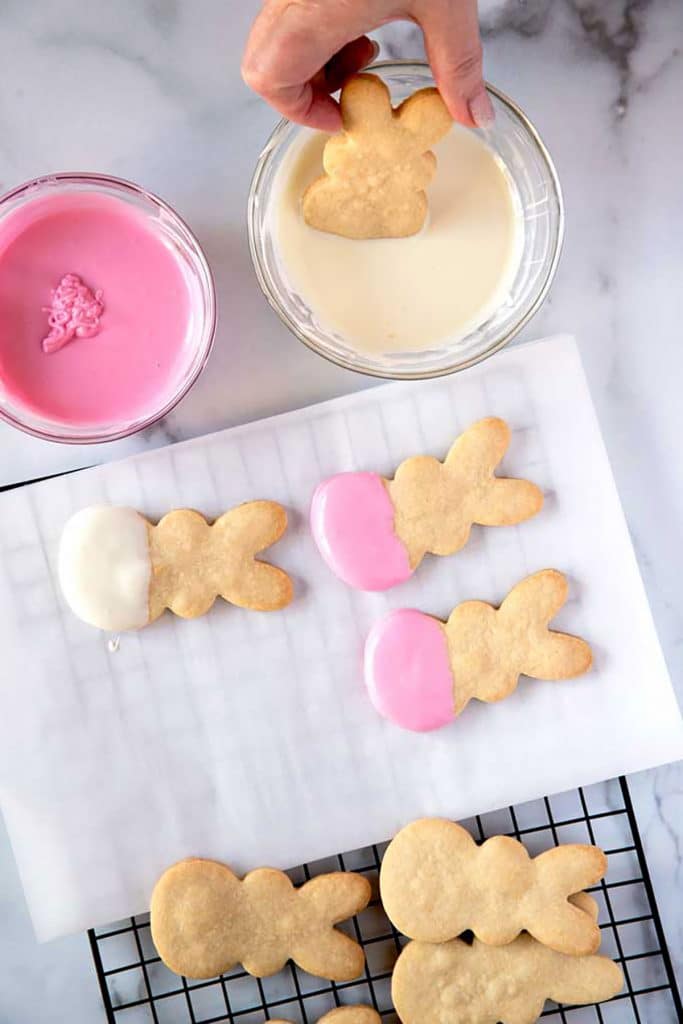 dipping the bunny cookies into melted white chocolate