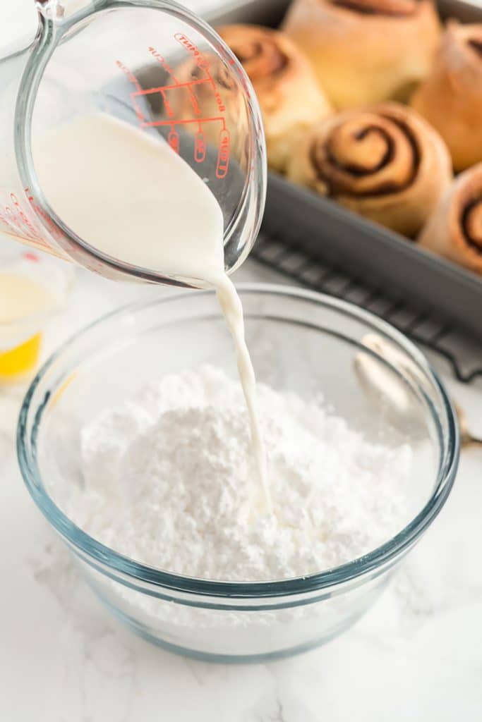 pouring heavy cream over confectioners' sugar