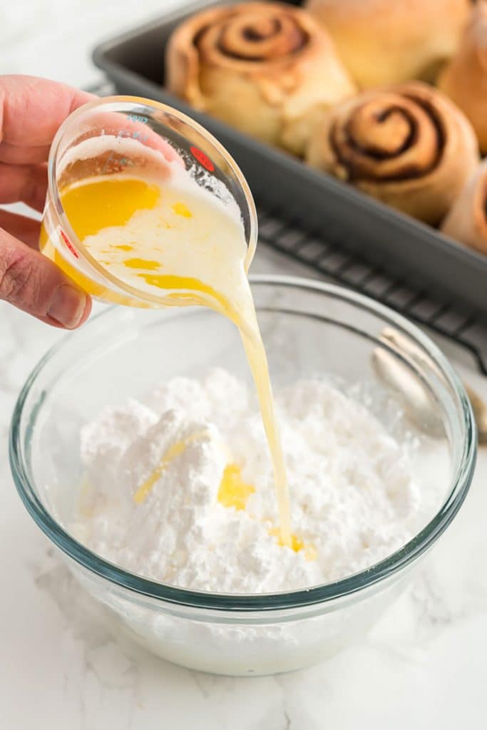 pouring melted butter over confectioners' sugar