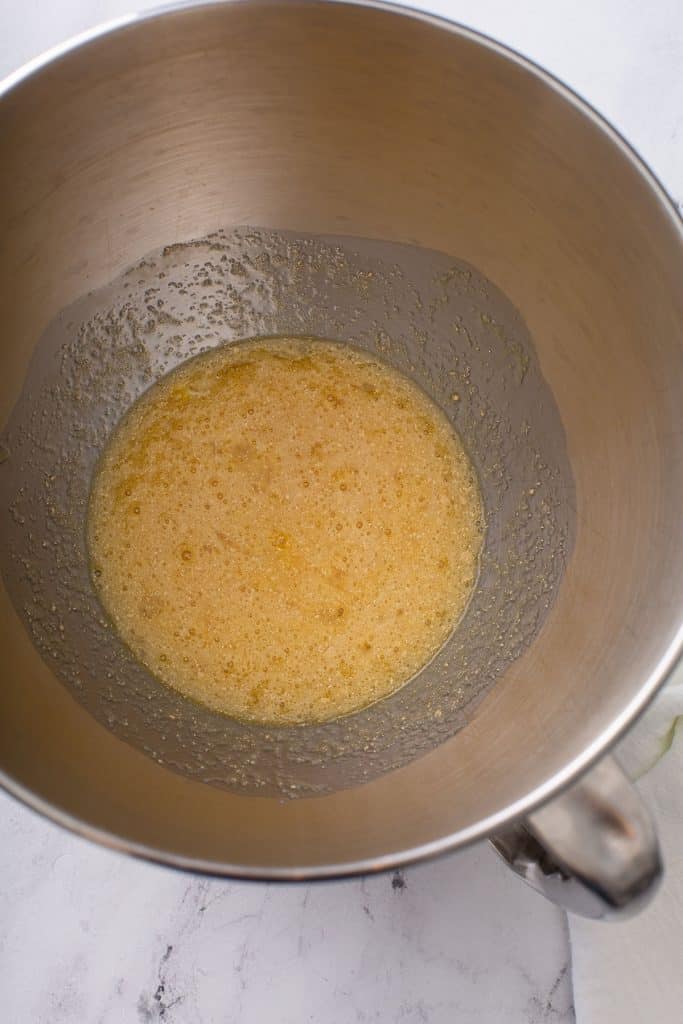 butter, eggs and milk mixed together in a mixing bowl.