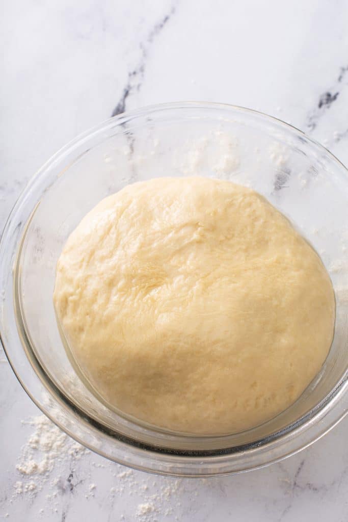 Italian bread dough shaped into a ball in a bowl