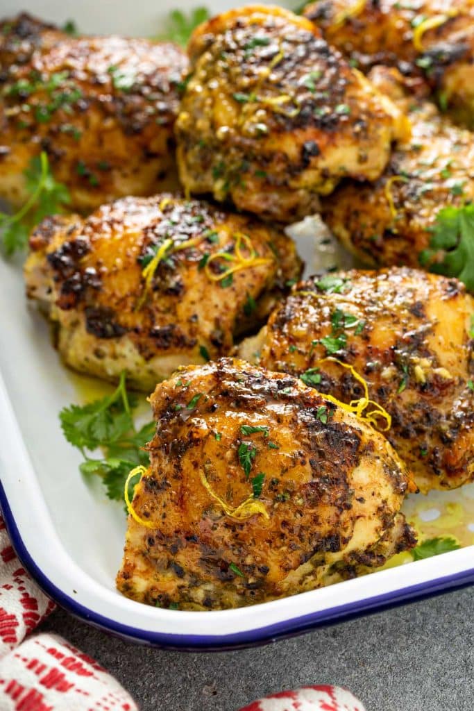 Golden brown chicken thighs piled up on a platter.