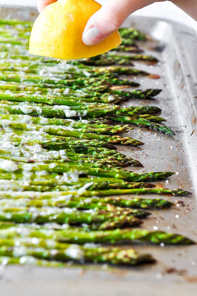 Squeezing fresh lemon over roasted asparagus