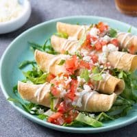 crispy taquitos with assorted toppings.