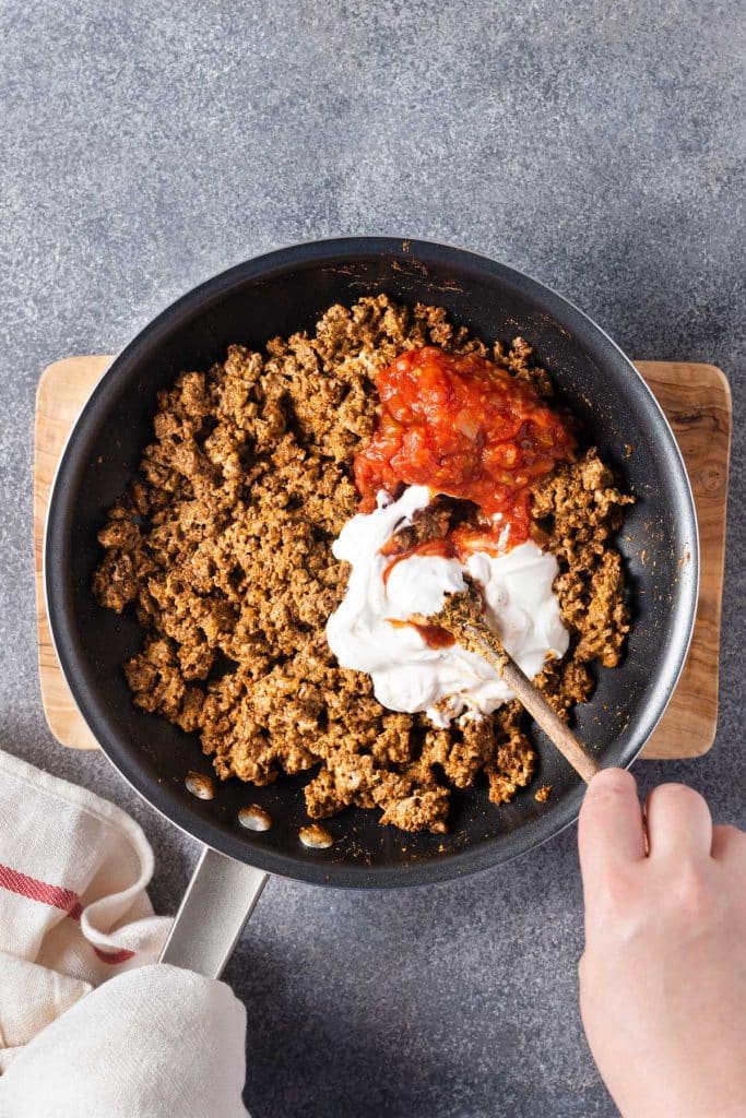 Seasoned ground beef, sour cream and salsa in a skillet