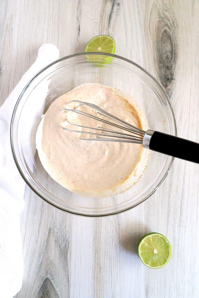 creamy chili lime dressing in a bowl with a whisk