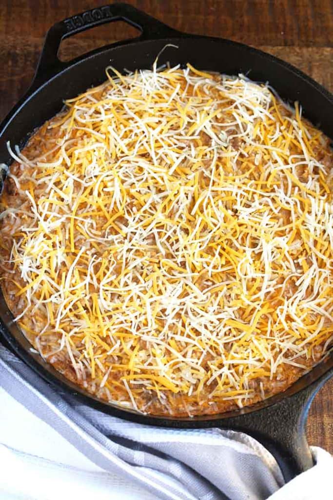 shredded cheese on top of the taco dip.