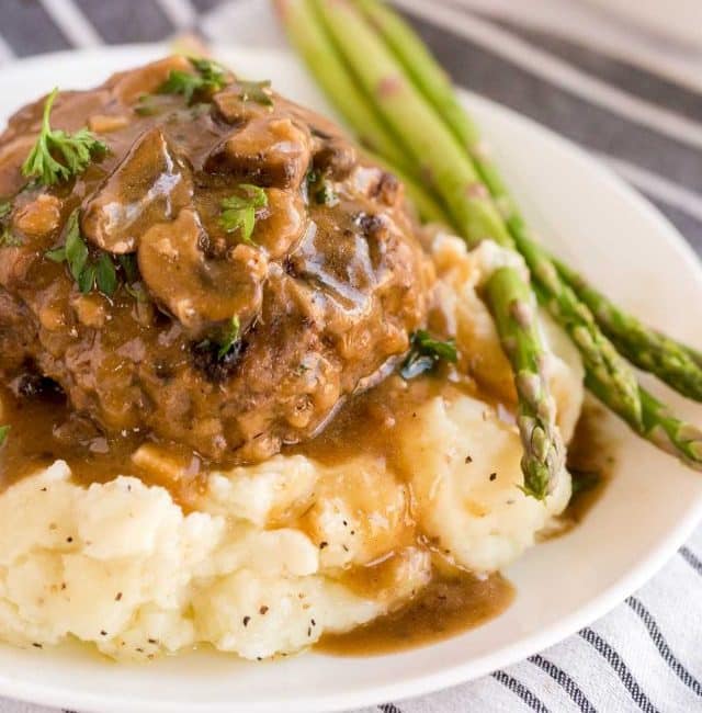 salisbury steak over mashed potatoes with asparagus on the side