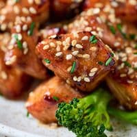 Close up view of golden brown caramelized salmon bites with sesame seeds