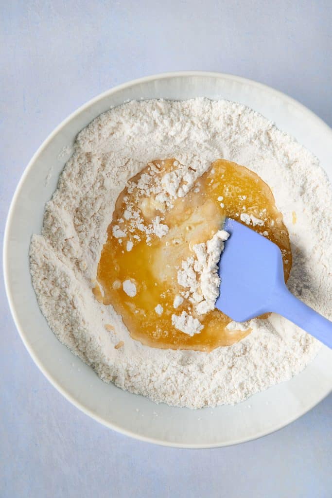 wet and dry ingredients in a bowl with a rubber spatula