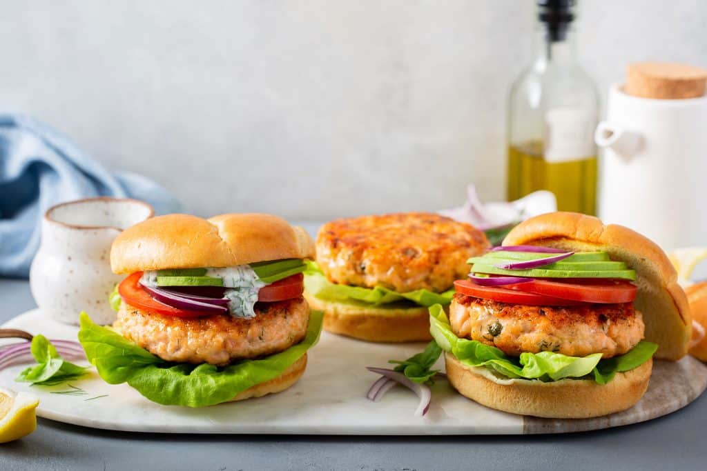 Three salmon burgers on buns