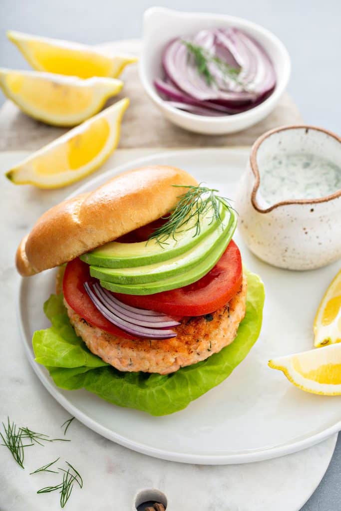 A salmon burger on brioche bun with toppings