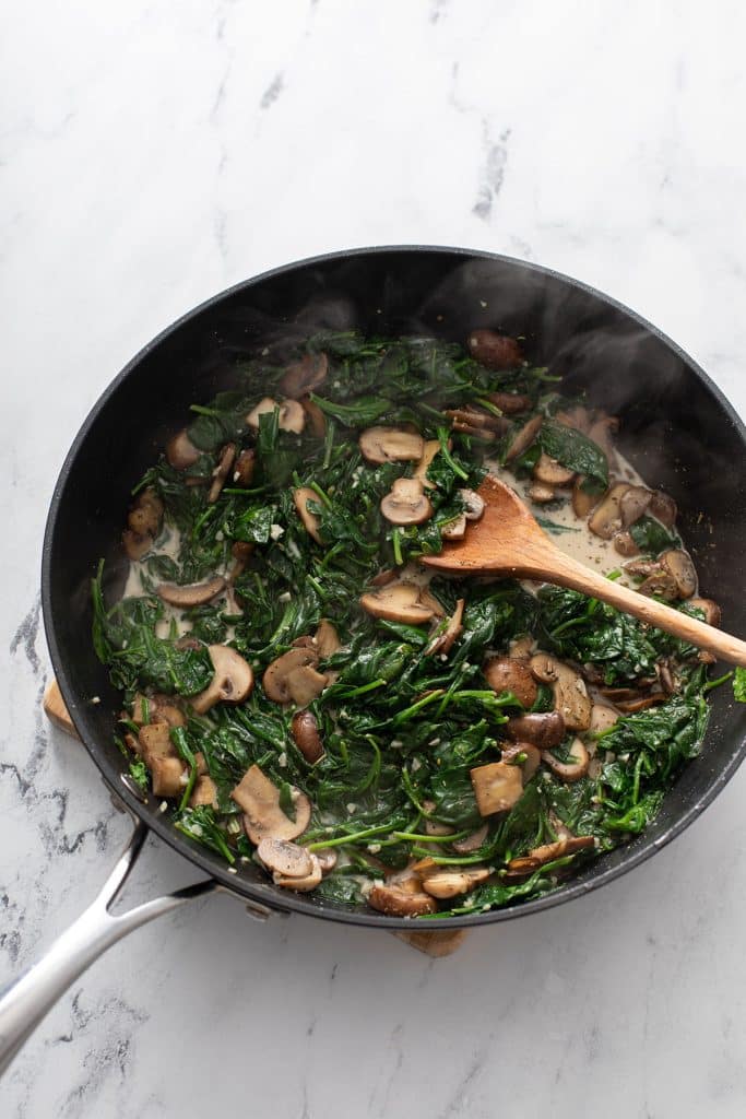 Sautéed mushrooms and spinach in a skillet
