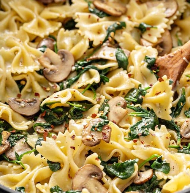 close up to a creamy parmesan spinach mushroom pasta on a skillet