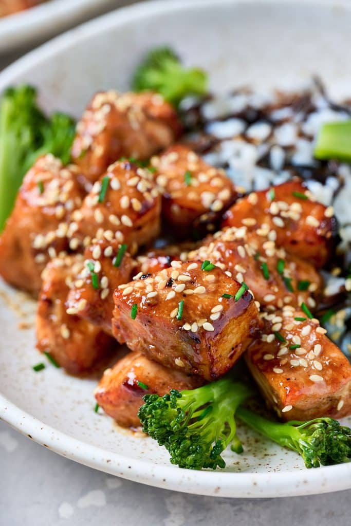 Golden brown sticky salmon bites with sesame seeds.