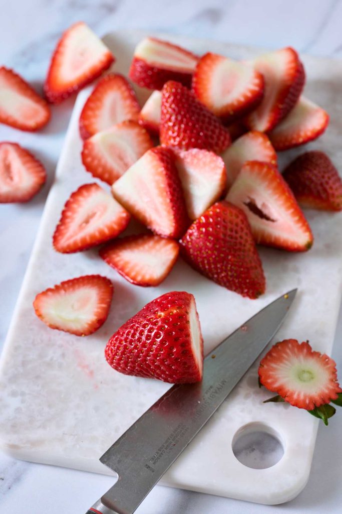 Cutting strawberries on a marble cutting board