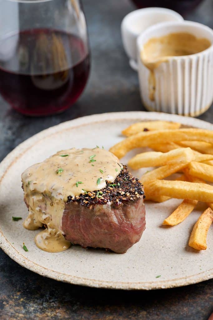 closeup of steak au poivre with french fries