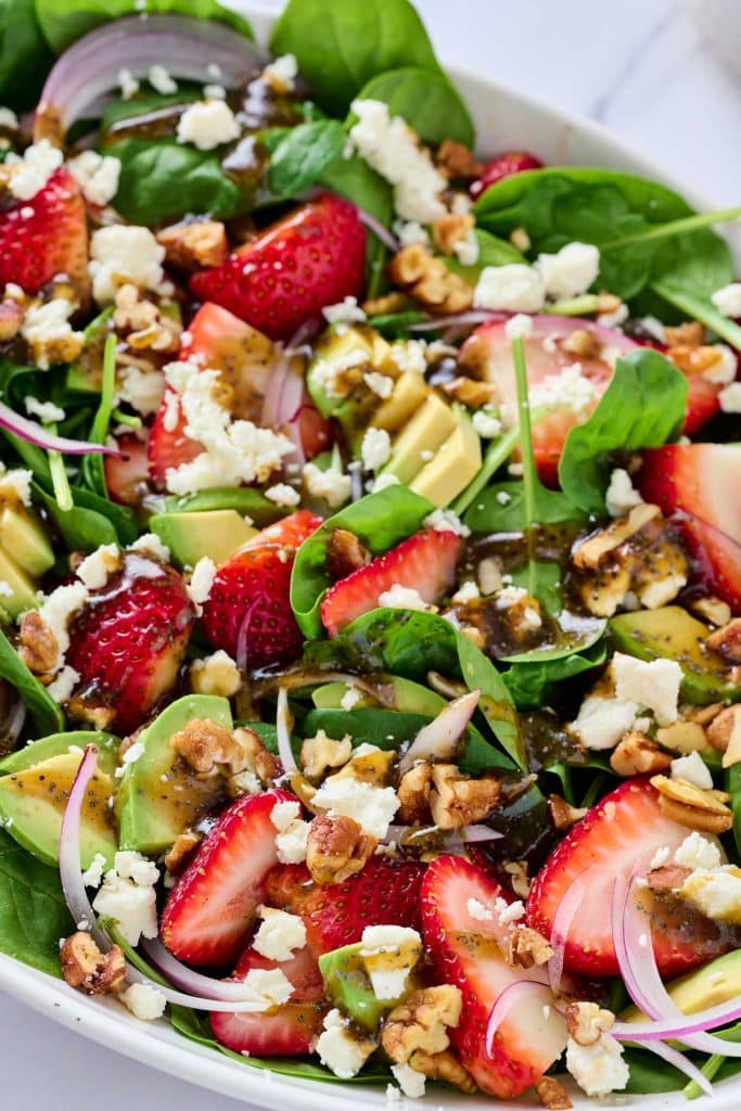 strawberries, spinach, thinly sliced red onion, candied pecans and feta cheese tossed with vinaigrette.