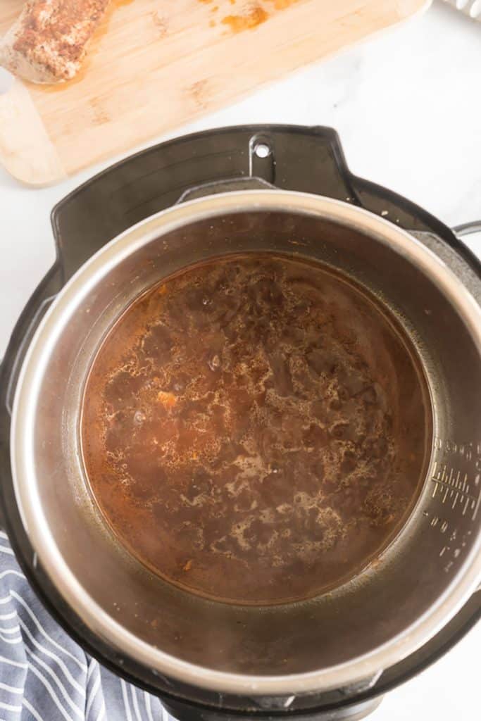 top view of broth and seasoning in instant pot