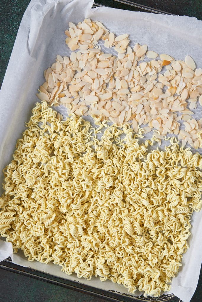 Crushed ramen noodles ans almond slivers on a sheet pan