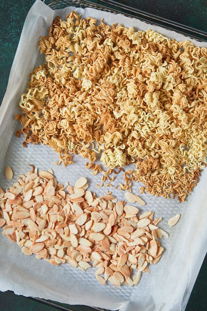 Toasted ramen noodles and almonds on a sheet pan.