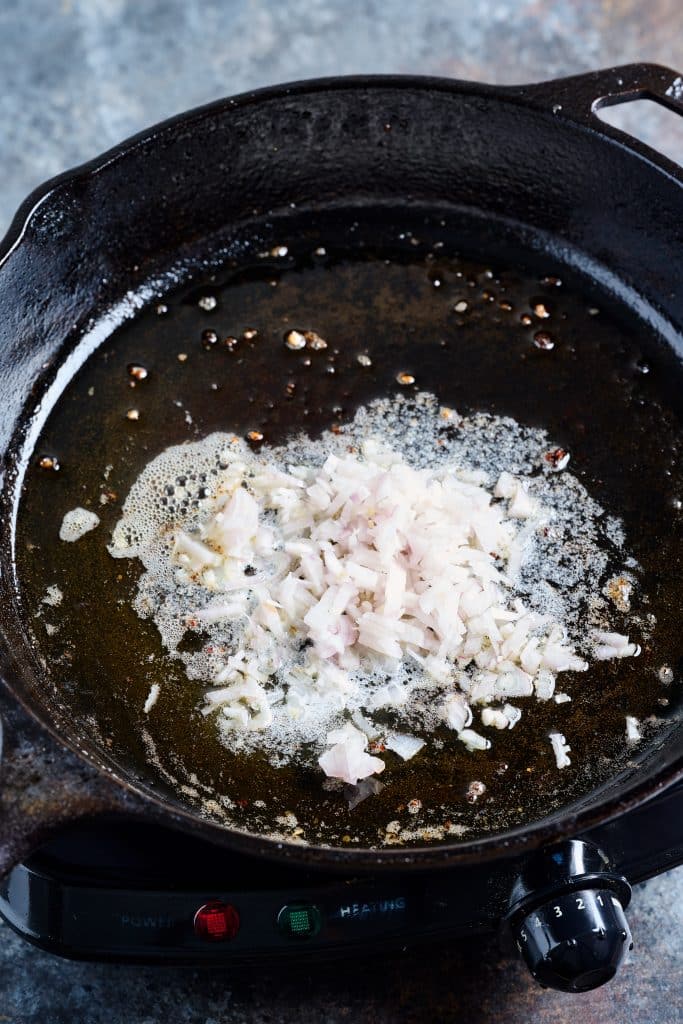 Sautéing shallots in a large skilet.