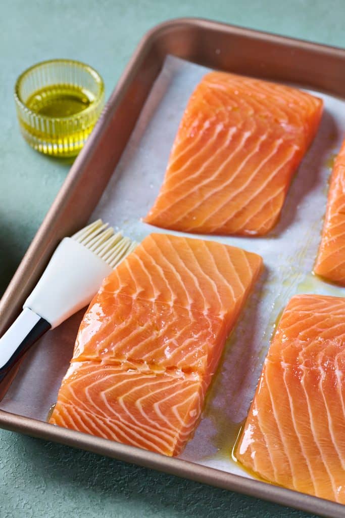 Raw salmon fillets coated with olive oil