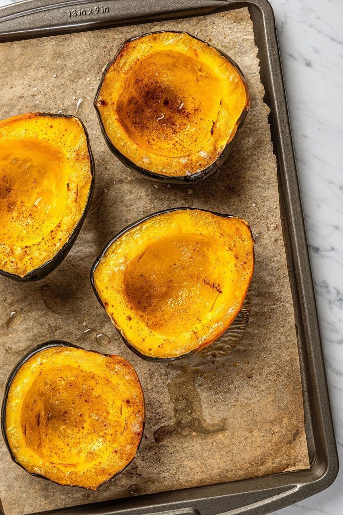 caramelized and tender roasted acorn squash on a sheet pan