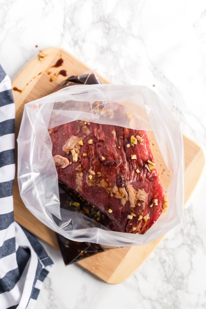 Removing marinated steak from a resealable bag.