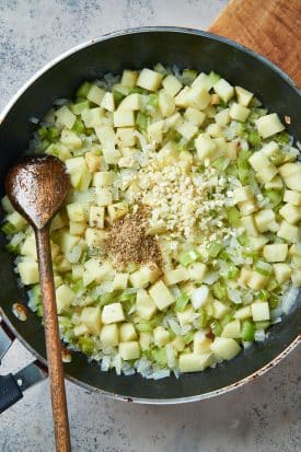 garlic and poultry seasoning on cooked onions, celery and apples
