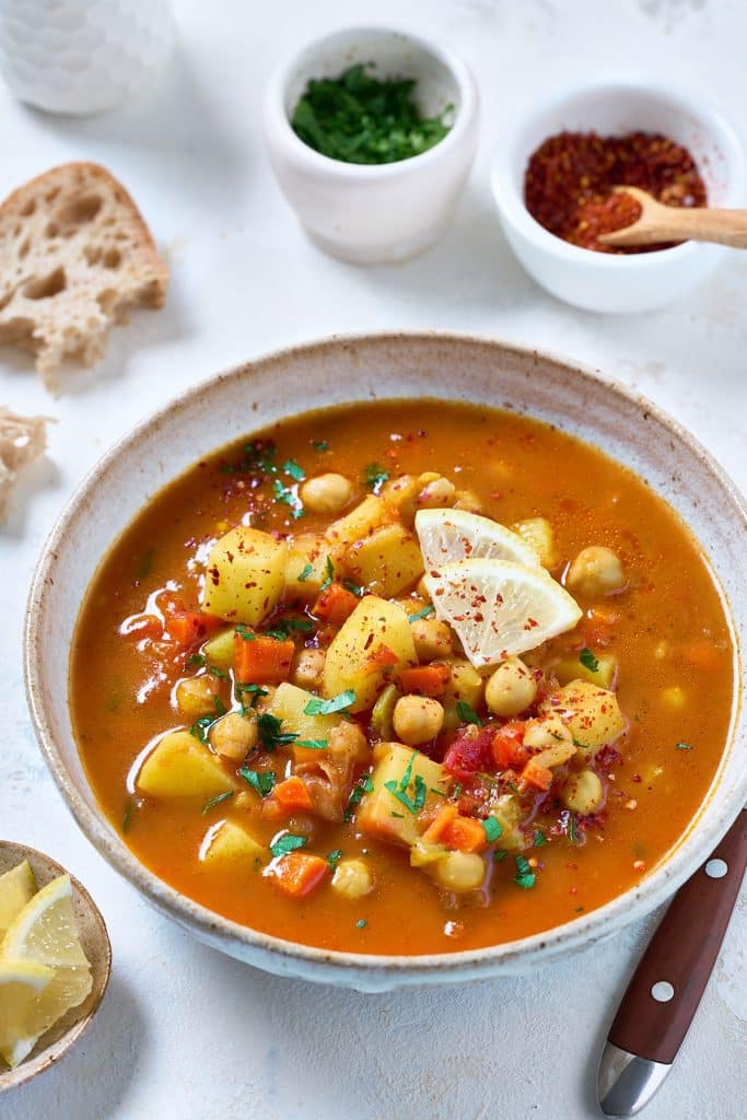 A bowl filled with chickpea, potato and vegetables soup.